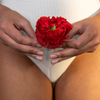Holding a flower over a menstrual cup